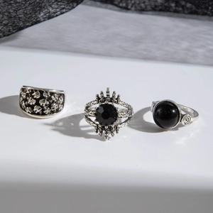 Detailed close-up of gothic silver rings set with black gemstones and skull reliefs