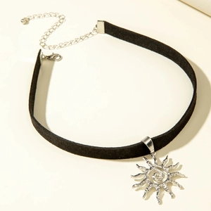 Detail van een zwarte fluwelen choker met zilveren zonnehanger en verstelbare sluiting