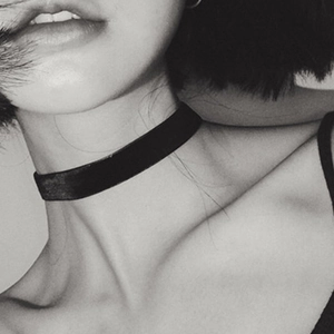Close-up van zwarte fluwelen gothic choker ketting op model in zwart-wit artistieke foto