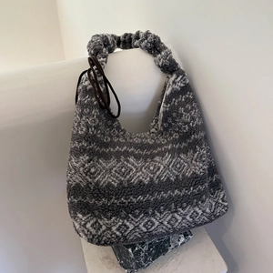 Detailed close-up of fuzzy gray diamond pattern tote bag on a minimalist stone display