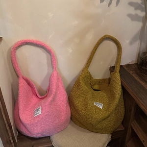 Detail of plush hobo bags in pink and mustard yellow with fuzzy faux fur texture