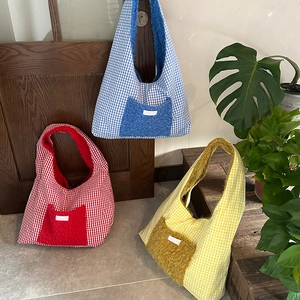Detail of grid pattern fabric and plush pocket on casual patchwork tote bag