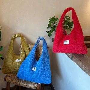 Detail of plush tote bags in yellow, blue, and red with checkered lining and SEE YOU tag