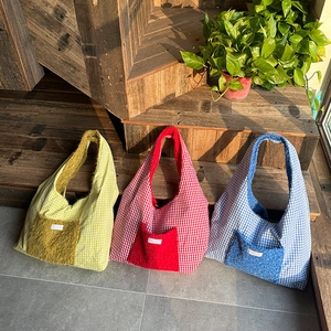 Three minimalist plaid tote bags in yellow, red, and blue with plush front pockets