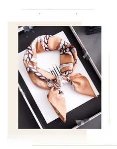 Detail of a luxury silk-like square scarf featuring retro chain link patterns in earthy tones
