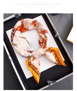 Detail of silk-texture scarf with horse patterns in a luxury gift box packaging