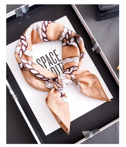 Detailed view of luxury silk scarf with elegant rope pattern texture in a gift box