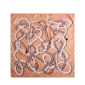 Elegant warm orange silk square scarf with contrasting rope patterns and floral pendants