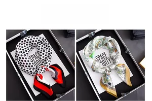 Polka dot and floral silk scarves displayed in a minimalist black tray with decorative card