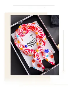 Detail of colorful daisy print silk scarf with red floral patterns on cream fabric