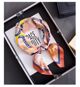 Detailed view of polka dot silk square scarf with vintage patterns tied on a gift card