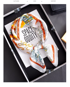 Detail of colorful retro floral silk scarf with vibrant orange border in display box