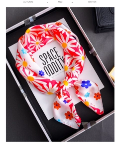 Detailed view of daisy pattern satin silk square scarf folded in a gift box packaging