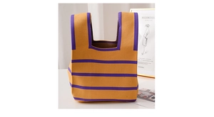 Gros plan d'un sac cabas en tricot rayé jaune et violet posé sur une table élégante