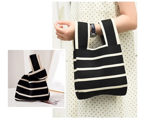 Détail du sac cabas en tricot rayé montrant la texture tissée et le motif noir et blanc