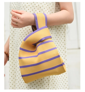 Détail de la texture en tricot épais et du motif à rayures jaunes et mauves sur le sac