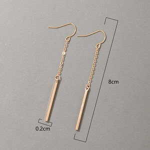 Detail view of gold long bar drop earrings showing 8cm length and minimalist design