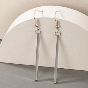 Macro shot of silver minimalist geometric stick earrings with elegant fishhook drops