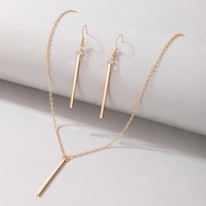 Close-up of minimalist gold rectangular bar pendant necklace and matching drop earrings