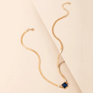 Elegant gold snake chain necklace featuring a square deep blue gemstone pendant on a warm background