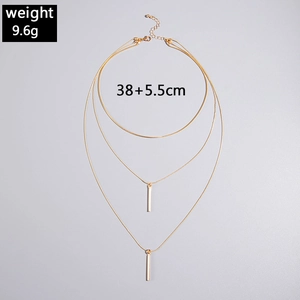 Detailed view of layered gold necklace with geometric rectangular bar pendants and length
