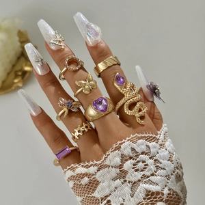 Primo piano di un set di anelli boho dorati con motivi a serpente e farfalla