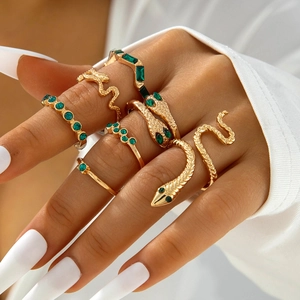 6-piece gold snake ring set with emerald green gemstones worn on fingers for stacking