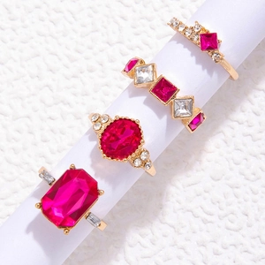 Dettaglio di set di quattro anelli con pietre rosso rosa e fasce color oro rosa
