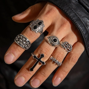 Macro detail of six-piece gothic punk ring set with skull and cross motifs on a hand