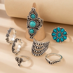 Close-up of vintage silver turquoise elephant rings with bohemian geometric carvings