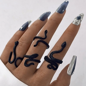 Close-up of four-piece black gothic snake ring set with textured metal scales on finger