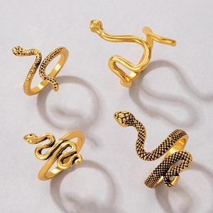 Macro detail of 4-piece vintage gold snake ring set with intricate scale texture and polish