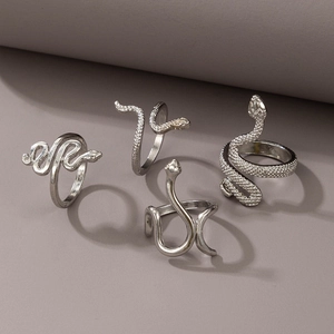 Detailed close-up of four vintage silver snake rings with realistic scale textures