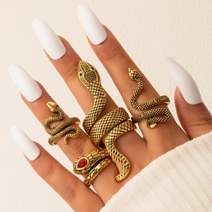 Close-up of vintage gold snake rings set with detailed scales and red gemstone eyes