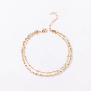 Detail of double-layer rhinestone anklet with iridescent crystals and golden bead chain