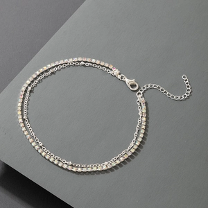 Close-up of double layer silver anklet with rainbow rhinestones and lobster clasp detail