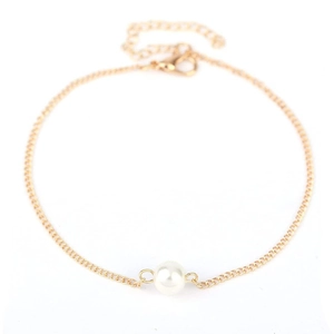 Detail of minimalist gold chain anklet featuring a single white pearl and lobster clasp