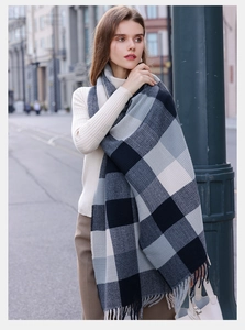 Dettaglio di sciarpa morbida a quadri con frange grigie e maglione beige chic