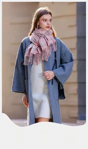 Détail de l'écharpe à carreaux rose et bleu clair avec franges sur manteau