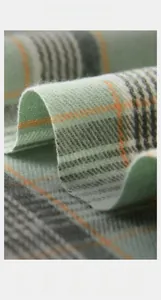 Gros plan de la texture douce d'écharpe à carreaux façon cachemire vert et orange
