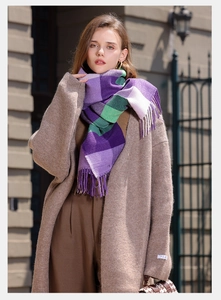 Scatto street style di una lunga sciarpa a quadri viola con nappe su un cappotto