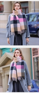 Dettaglio di sciarpa in maglia morbida a quadri rosa con lunghe nappe a frangia
