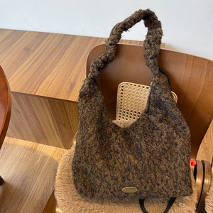 Brown faux fur drawstring shoulder bag with golden metal logo and textured plush finish