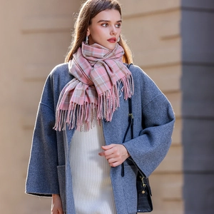 Écharpe à carreaux rose et beige toucher cachemire avec franges sur un manteau gris foncé