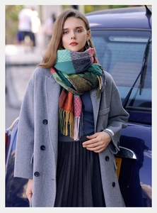Outdoor street style shot of a thick multi-color plaid tassel scarf with wool coat