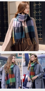 Detail of soft plaid scarf with tassels in vibrant blue and warm red checkered patterns