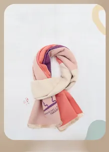 Detailed close-up of a warm pink and purple knit winter scarf for kids with soft tassels