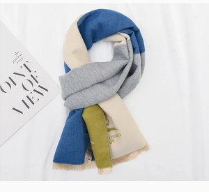 Detail of soft color-block winter scarf with fringe trim and logo print accents