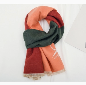 Detail of color-block knit scarf with orange, burgundy, and green panels with tassels