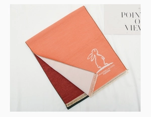 Detail of kids winter scarf with white rabbit print and soft fringed edges in salmon pink